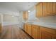 Bright kitchen with wood flooring, cabinets, and a stainless steel dishwasher; view to the living room at 115 Trickle Dr, Summerville, SC 29483