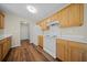 A well-lit kitchen showcases wooden cabinets, white appliances, and a doorway that leads outside at 115 Trickle Dr, Summerville, SC 29483