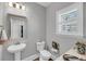 Charming half bathroom with pedestal sink, stylish mirror, and window with plantation shutters at 1173 Triple Crown Court, Mount Pleasant, SC 29429