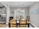 The open dining room features hardwood floors, an elegant chandelier, and ample natural light at 1173 Triple Crown Court, Mount Pleasant, SC 29429