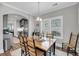 The open dining room features hardwood floors, an elegant chandelier, and ample natural light at 1173 Triple Crown Court, Mount Pleasant, SC 29429