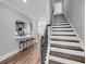 Hallway with dark wood stairs, kitchen with bar seating, and bright lighting at 1173 Triple Crown Court, Mount Pleasant, SC 29429