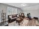 Cozy living room with luxury vinyl flooring, a brown leather couch, and natural light at 1173 Triple Crown Court, Mount Pleasant, SC 29429