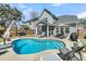 Backyard view of sparkling pool, screened in porch, and lush landscaping at 1173 Triple Crown Court, Mount Pleasant, SC 29429