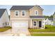 Two-story home with tan siding, a front porch, and a two car garage at 123 Moscato Ln, Summerville, SC 29485