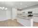 Bright kitchen features white cabinets, granite countertops, stainless appliances, and a stylish chandelier for a modern look at 123 Moscato Ln, Summerville, SC 29485