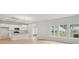 Open-concept living room and kitchen with light wood floors, white cabinets, and stainless steel appliances at 123 Moscato Ln, Summerville, SC 29485