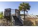 Private pier access featuring wooden stairs, gate, and a sandy path, enhancing beachfront living at 1300 Ocean Blvd # 139, Isle of Palms, SC 29451