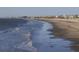 Scenic view of beach with ocean waves and people walking along the coastline, and houses in the background at 1300 Ocean Blvd # 139, Isle of Palms, SC 29451
