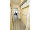 Hallway with wood-look floors leading to living area with built-in shelves and murphy bed at 1300 Ocean Blvd # 139, Isle of Palms, SC 29451
