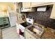 Compact kitchen featuring stainless steel sink, electric stove, and tile backsplash at 1300 Ocean Blvd # 139, Isle of Palms, SC 29451
