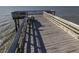 Wooden pier extending into ocean with a small platform at the end and benches at 1300 Ocean Blvd # 139, Isle of Palms, SC 29451