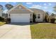 Charming single-story home with a two-car garage, beautiful landscaping, and well-maintained lawn at 1309 Basketweaver Way, Hanahan, SC 29410