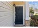 Close-up of a home's front entry featuring a stylish black door, stone accents, and a welcoming exterior light at 1309 Basketweaver Way, Hanahan, SC 29410