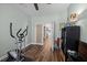 View of the home gym with fitness equipment, ceiling fan, door, and beautiful wood flooring at 1309 Basketweaver Way, Hanahan, SC 29410