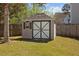 Outdoor backyard shed featuring painted crossbuck doors, window with shutter, and shingle roof at 1309 Basketweaver Way, Hanahan, SC 29410