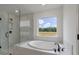 Primary bathroom with soaking tub, glass shower, and natural light at 134 Palfrey Dr, Ridgeville, SC 29472