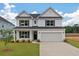 Charming two-story home with landscaped front yard and attached two-car garage at 134 Palfrey Dr, Ridgeville, SC 29472