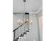 Close-up of a decorative chandelier illuminating the staircase and dining area at 1450 Eutaw Battalion Dr, Charleston, SC 29412