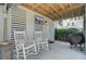 Relaxing covered patio featuring rocking chairs, a TV, and a grill for outdoor living at 1450 Eutaw Battalion Dr, Charleston, SC 29412