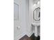 Modern powder room with pedestal sink, stylish mirror and dark wood floors at 1450 Eutaw Battalion Dr, Charleston, SC 29412