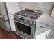 Close-up of a stainless steel gas range and oven, complemented by white cabinets and a tile backsplash at 1450 Eutaw Battalion Dr, Charleston, SC 29412