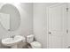 Clean half bathroom featuring a toilet and pedestal sink with a round mirror at 1651 Valley Oak Rd, Johns Island, SC 29455