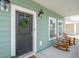 Inviting front porch with rocking chairs, a wreath, and charming exterior lighting at 1651 Valley Oak Rd, Johns Island, SC 29455