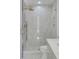 Glass shower with modern gold fixtures and white tile at 178 Beresford Creek St, Daniel Island, SC 29492