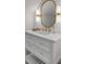Bathroom vanity with white countertops, grey cabinets, gold hardware and oval mirror at 178 Beresford Creek St, Daniel Island, SC 29492