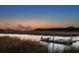 Waterfront dock with boat, offering a peaceful setting with scenic waterway views at sunset at 178 Beresford Creek St, Daniel Island, SC 29492