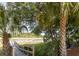 Picturesque view of a wooden dock and boat lift, surrounded by lush greenery and palm trees at 178 Beresford Creek St, Daniel Island, SC 29492