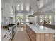 Spacious kitchen island with stainless steel faucet, marble countertops, and double doors to patio at 178 Beresford Creek St, Daniel Island, SC 29492
