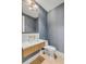 Modern powder room with textured blue wallpaper, gold fixtures, and hardwood floors at 178 Beresford Creek St, Daniel Island, SC 29492