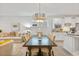 Open-concept dining area featuring modern lighting, a large wooden table and chairs, connecting the kitchen and living room at 178 Garden Gate Way, Summerville, SC 29486