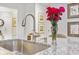 Close-up of a kitchen island highlighting the faucet, sink, granite countertops, and vase of flowers at 178 Garden Gate Way, Summerville, SC 29486