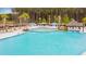 Large pool area featuring umbrellas, cabanas, lounge chairs and lush landscaping, creating a resort-style atmosphere at 178 Garden Gate Way, Summerville, SC 29486