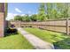 Backyard with grass, wooden fence, and concrete pathway leading to a gated area at 1861 Jaywood Cir, Charleston, SC 29407