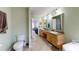 Bright bathroom featuring dual sinks, vanity cabinets, and neutral tiling, complemented by soft green walls at 1925 Old Parsonage Rd, Charleston, SC 29414