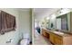 Bright bathroom with dual sinks, vanity cabinets, and neutral tiling, complemented by soft green walls at 1925 Old Parsonage Rd, Charleston, SC 29414