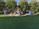 Backyard oasis with decorative water feature, artificial turf, and manicured hedges creating a serene retreat at 2009 Utsey St, Johns Island, SC 29455