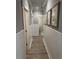 Hallway featuring beautiful hardwood floors, decorative wall paneling, and framed artwork at 2009 Utsey St, Johns Island, SC 29455