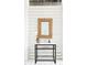 Stylish bathroom featuring a vanity with a woven mirror and modern fixtures set against a white plank wall at 204 E Huron Ave, Folly Beach, SC 29439