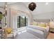 Bright bedroom with large windows, neutral walls, and yellow accent pillows at 204 E Huron Ave, Folly Beach, SC 29439