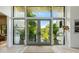 Bright foyer with tall windows and glass doors offering views of greenery and natural light at 204 E Huron Ave, Folly Beach, SC 29439