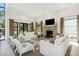 Bright living room with a fireplace, white shiplap walls, and multiple windows offering views to the outside at 204 E Huron Ave, Folly Beach, SC 29439