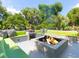 Inviting outdoor lounge area with a modern fire pit, comfortable seating, and lush tropical landscaping at 204 E Huron Ave, Folly Beach, SC 29439