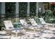 Inviting pool area with comfortable lounge chairs and side tables, surrounded by lush, well-maintained greenery at 204 E Huron Ave, Folly Beach, SC 29439