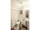 Cozy bathroom with hardwood floors, a toilet, pedestal sink, and decorative mirror at 2049 Maybelles Ln, Charleston, SC 29414