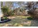 Private backyard with mature trees, green grass and a wooden fence that provides seclusion and tranquility at 2050 S Smokerise Way, Mount Pleasant, SC 29466